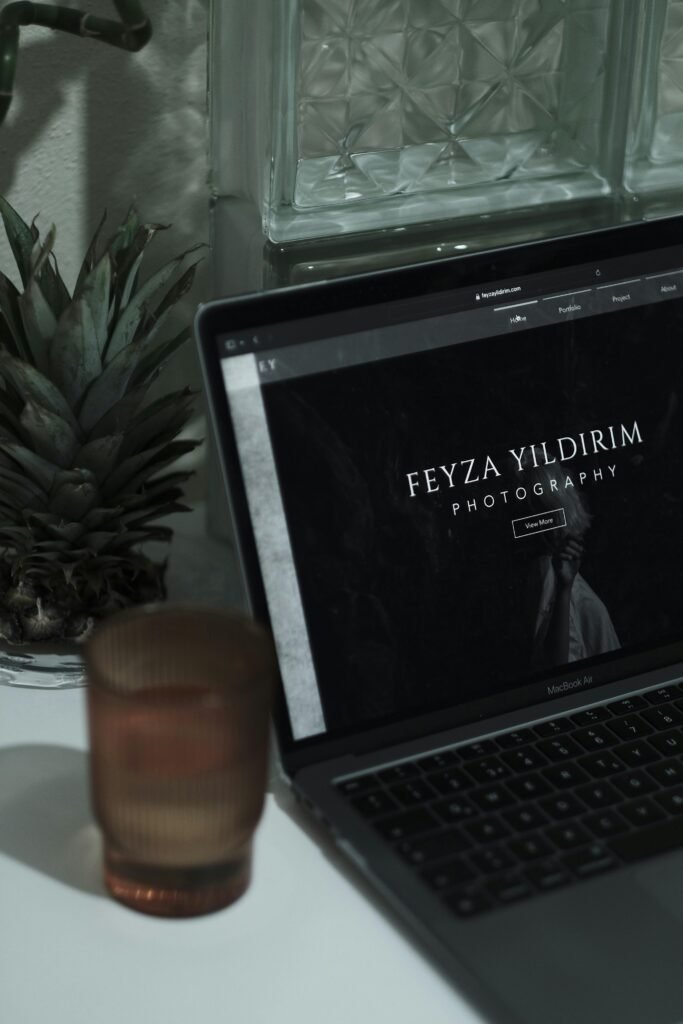 pexels-photo-19876064-19876064 An aesthetically pleasing workspace featuring a laptop with a photographer's website, surrounded by minimalist decor.
