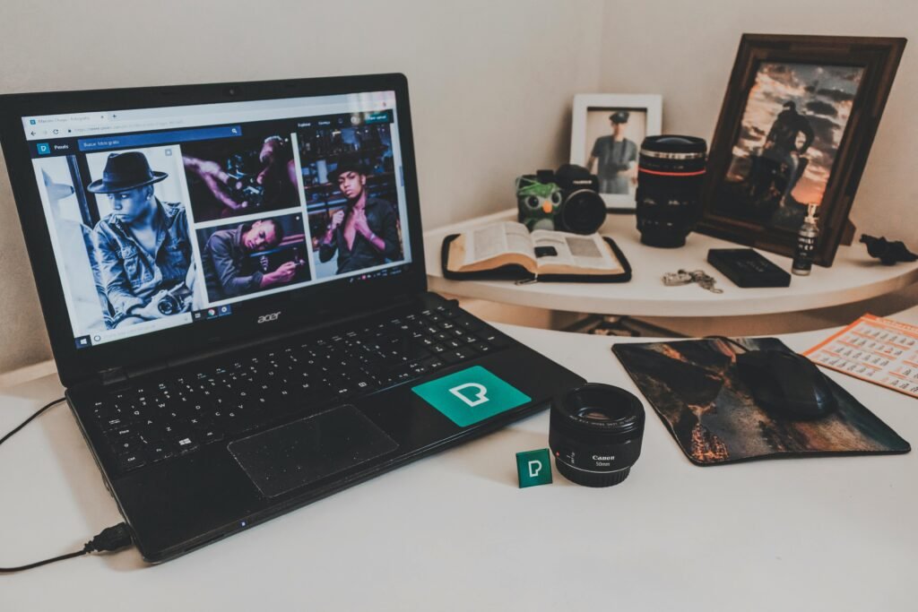 pexels-photo-2183773-2183773 A modern workspace featuring a laptop, photography equipment, and an open book on a desk.