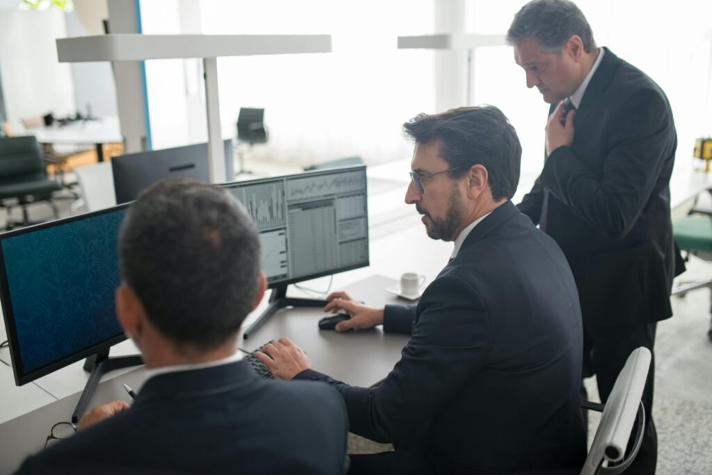 pexels-photo-8353831-8353831 Colleagues in a modern office reviewing stock market trends and data on multiple screens.