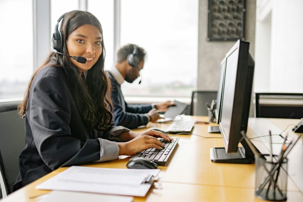 pexels-photo-8867434-8867434 Smiling call center agents in an office providing customer support on computers.