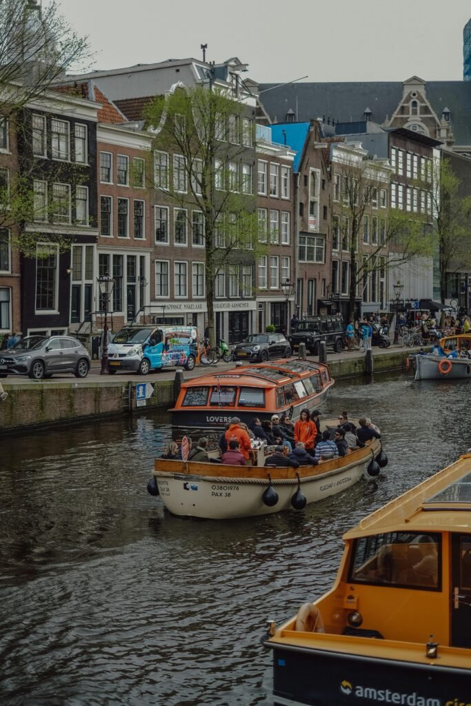 pexels-photo-32350081-32350081 Boats navigating the scenic canals of Amsterdam with historical buildings in the backdrop.